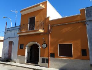 阿韦特拉纳I tre feudi - Casa Vacanza的一座橙色和白色的建筑,上面有时钟
