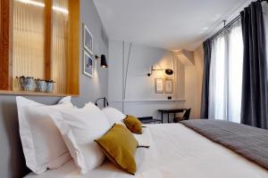 巴黎Tinah Paris, Réaumur - Montorgeuil的一间卧室配有白色床和黄色枕头