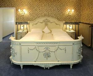 沃尔普斯韦德布城霍夫酒店的一张大白色的床,位于带两张桌子的房间