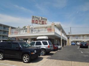 大洋城Sifting Sands Motel的汽车停泊在停车场的汽车旅馆