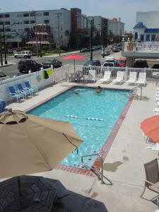 大洋城Sifting Sands Motel的一个带椅子和遮阳伞的大型游泳池