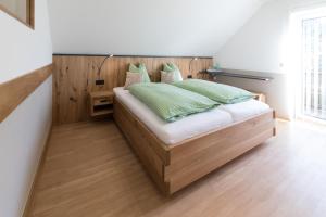 Rein斯库斯特保尔旅馆的一间卧室配有一张带绿色枕头的木床。