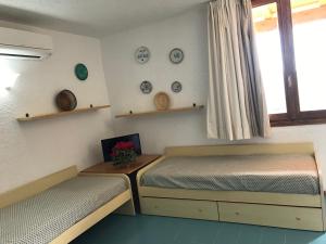 马里纳·迪·波迪斯科库娜娜中央度假公寓式酒店的一间卧室设有两张床,窗户配有盘子