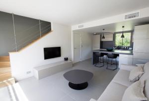 维琪奥港内拉海岸公寓的客厅配有白色的沙发和桌子