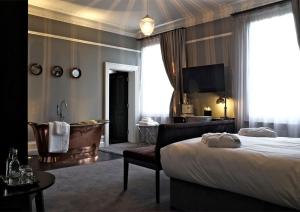 伊利诗人之家酒店的一间卧室配有一张床、一个浴缸和一台电视。