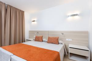 圣地亚哥港环球塔迈莫热带酒店的一间卧室配有一张带橙色毯子的床