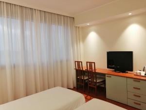 塞格拉泰Best Western Air Hotel Linate的酒店客房设有一张桌子、一台电视和一张床