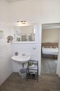 卡塞塔卡瑟迷人酒店的一间带水槽和镜子的浴室以及一张床
