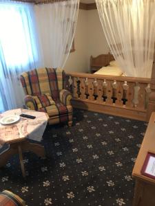 瓦门施泰纳赫普瑞灵格兰德宫酒店的一间卧室配有一张床、一把椅子和一张桌子