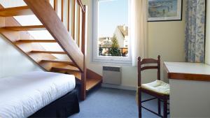 贝诺代Les Bains de Mer Riviera Bretonne的客房设有楼梯、床和窗户。