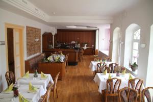 安姆茨堡维里斯池别墅酒店的一间带白色桌椅的餐厅和一间厨房