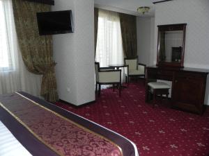 克勒拉希赫斯提亚酒店的酒店客房带一张床、一张书桌和一面镜子
