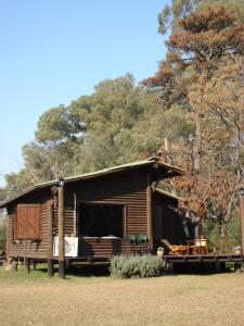 皮拉尔皮拉尔薰衣草山林小屋的小木屋设有门廊、桌子和椅子