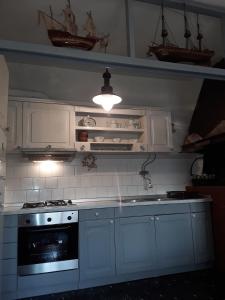 ZapunteloAdorable Summer house by the sea的厨房配有白色橱柜和炉灶烤箱。