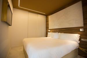 圣塞瓦斯蒂安Boulevard Luxury by Sebastiana Group的卧室配有白色的床和墙上的绘画作品