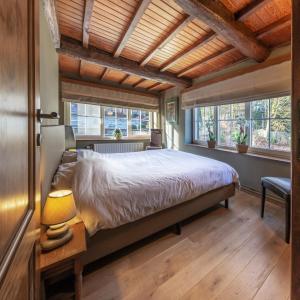 Laforêt拉塔巴提度假屋的一间卧室设有一张大床和两个窗户。