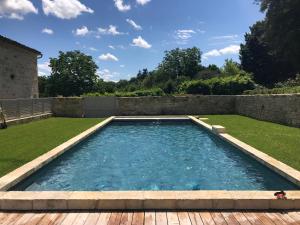 Magnac-sur-TouvreChateau de Maumont的一个带木甲板的庭院内的游泳池