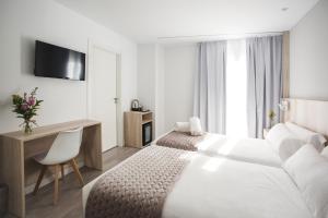 索里亚DWO Ábaster的酒店客房配有一张床、一张书桌和一台电视。