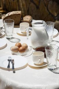 斯沃伦塔Kantouni Apartments的桌上放鸡蛋和盘子,还有牛奶