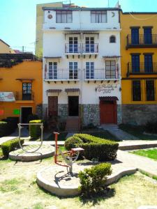 瓜纳华托Los Pueblitos de Guanajuato Hotel的一座白色和黄色的建筑,前面有一个院子