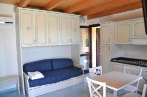 维拉西米乌斯棕榈乡村酒店的一间带蓝色沙发的客厅和一间厨房