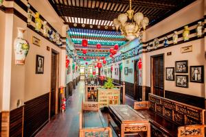 宋卡สงขลาแต่แรก แอนทีค โฮเท็ล Songkhla Tae Raek Antique Hotel的大楼内带桌椅的长走廊