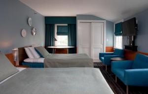 东汉普顿梅德斯通酒店的酒店客房,配有两张床和蓝色椅子