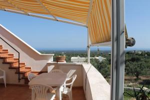 奥斯图尼La Mascherada的设有一个配有桌椅并享有美景的阳台。