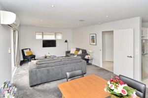 基督城Regents 94A - Christchurch Holiday Homes的客厅配有沙发和桌子