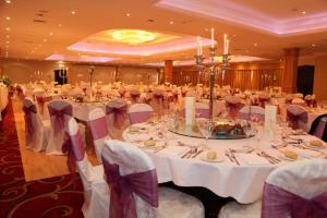 恩尼斯克朗钻石海岸酒店的一个带白色桌椅的大型宴会厅