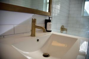 伊斯拉莫拉达Sunset Inn的浴室内白色水槽和金色水龙头