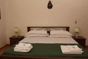 奥斯图尼La Mascherada的一间卧室配有带毛巾的床