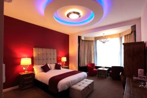 彼得伯勒明珠大酒店的一间卧室设有一张大床和红色的墙壁