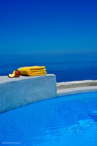 乔拉弗雷恩多斯Kifines Suites的游泳池旁的黄色毛巾
