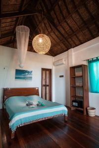 卢纳将军城Ferra Resort Siargao的一间卧室配有一张床,铺有木地板