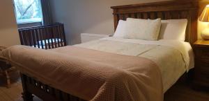 基拉尼Ethan House的一间卧室配有一张大床和木制床头板