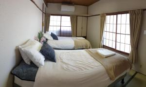 妙高Myoko Ski Lodge in Akakura Village的带2扇窗户的客房内的2张床