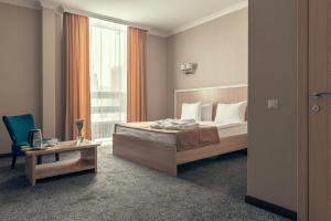 阿斯塔纳AYKUN Hotel by AG Hotels Group的一间卧室配有一张床、一张书桌和一个窗户。