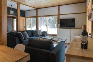 野沢Nozawa Gondola Apartments的客厅配有蓝色的沙发和电视