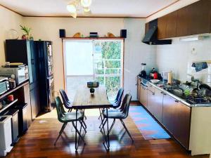 读谷村人生旅程旅馆的厨房配有桌椅和窗户。