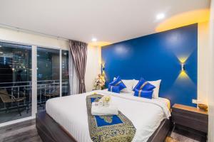 华欣Anchan Hotel & Spa的一间卧室设有一张蓝色墙壁的大床