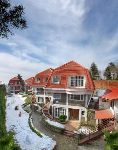 西姆拉Marigold Sarovar Portico Shimla的红色屋顶的大房子