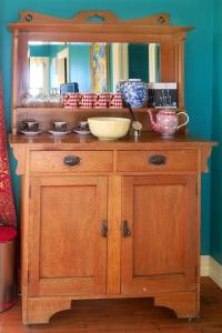 奥玛鲁Fantail Cottage的木柜,上面有镜子和碗