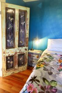 奥玛鲁Fantail Cottage的一间卧室配有一张床和一个带床头柜的梳妆台
