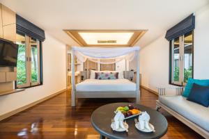 象岛Barali Beach Resort & Spa的一间卧室配有一张床和一张桌子及一碗水果