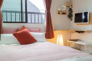 东京Cozy Vibes Apt Hotel的一间卧室配有红色和白色枕头的床