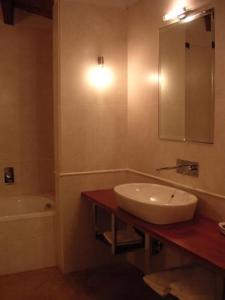 蒙卡尔沃La Locanda del Melograno的一间带水槽、浴缸和镜子的浴室