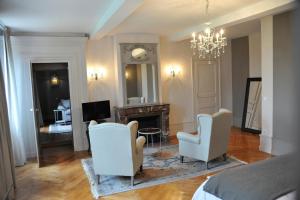 CordelleDomaine des Grands Cèdres的一间卧室设有壁炉和2把白色椅子