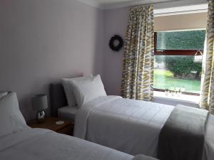 拉纳克The Annexe Cottage at Newhouse Farm的酒店客房设有两张床和窗户。