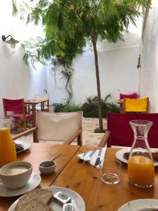 休达德亚HoMe Hotel Menorca的一张木桌,上面放着食物和橙汁